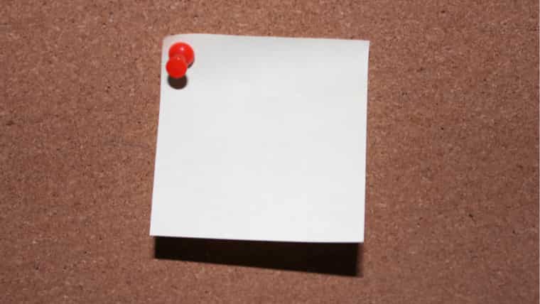 コルクボードに赤いピンでとめられた白い無地のメモの画像