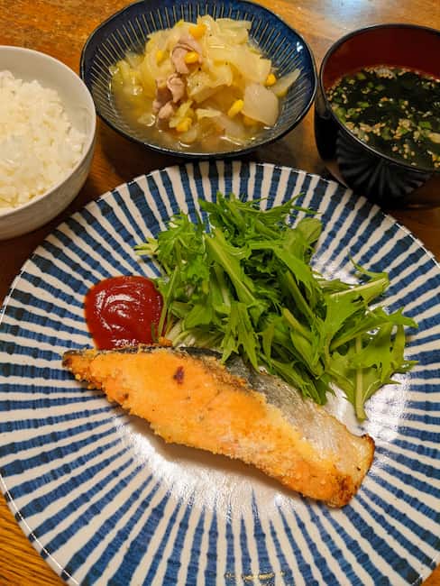 ヨシケイカットミール 中央 さけのチーズソテーと水菜、左上白飯、中央上 豚肉の塩バター煮、右上 わかめスープの画像