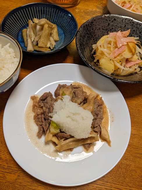 ヨシケイバランス400のメニュー　中央 牛肉のおろしのせ、左上白飯、中央上 たたきごぼう、右上 ハムとじゃが芋のレンジ蒸しの画像