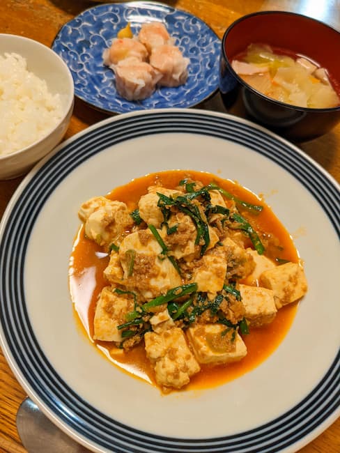 ヨシケイキットde楽のメニュー　中央麻婆豆腐、左上白飯、中央上 かに焼売、右上中華スープの画像
