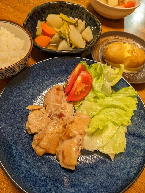 ヨシケイキットde楽のメニュー 中央鶏肉の塩糀焼き、左上白飯、中央上豚肉と大根の洋風煮、右上じゃがバターの画像